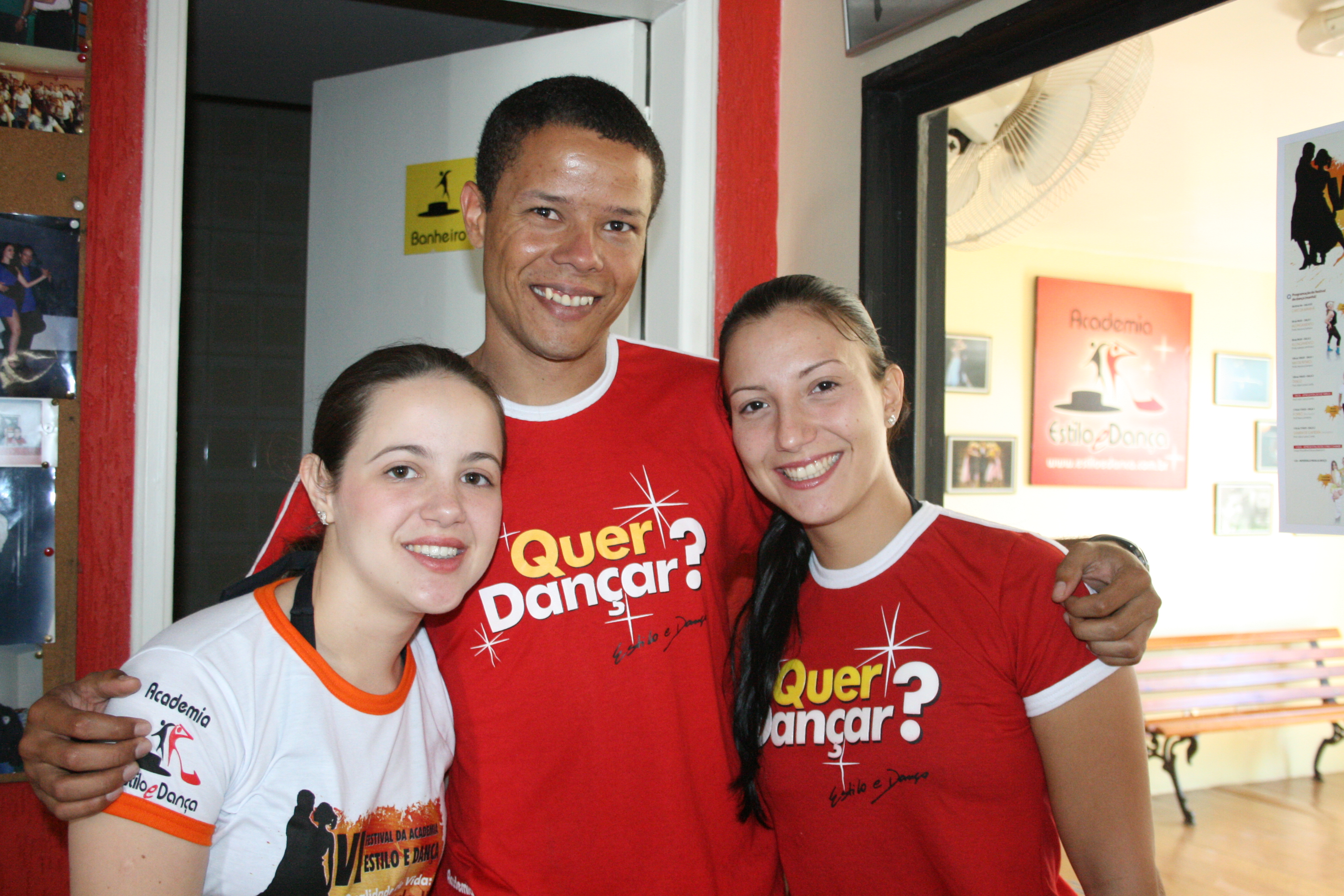 Três participantes com camisetas do evento reunidos em retrato