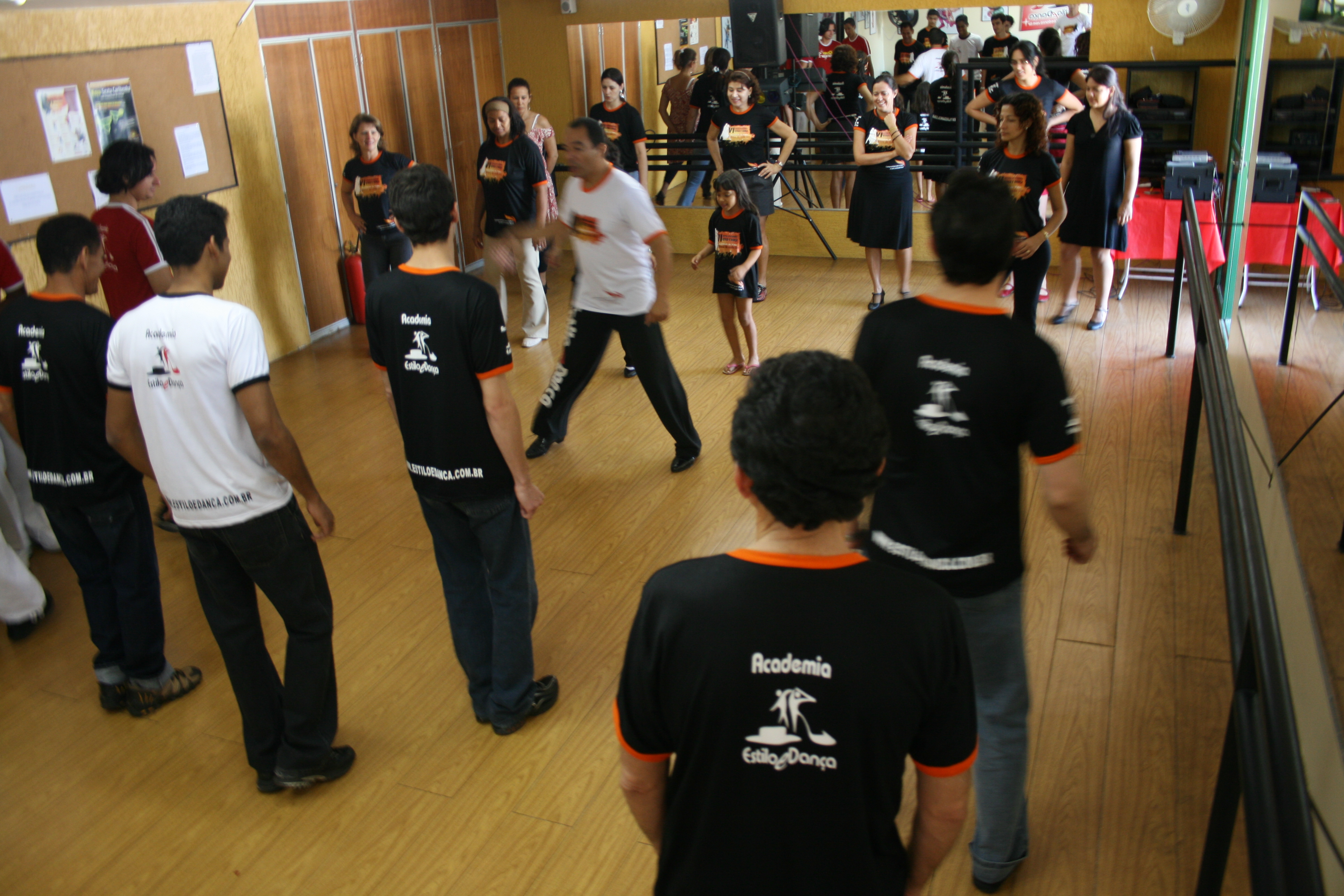 Grupo acompanha demonstração de dança no centro do salão