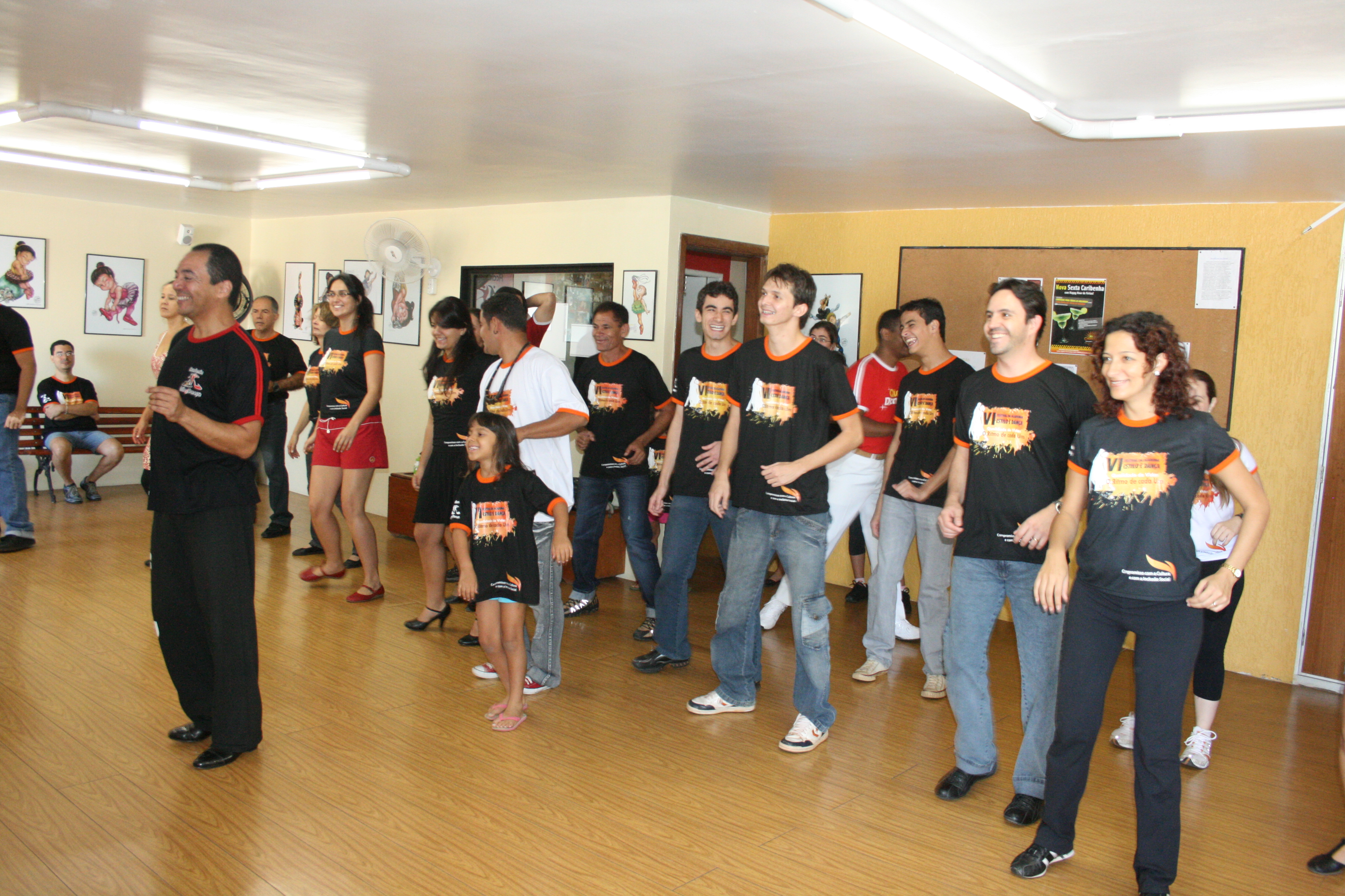 Participantes acompanham exercício de movimento em formação linear