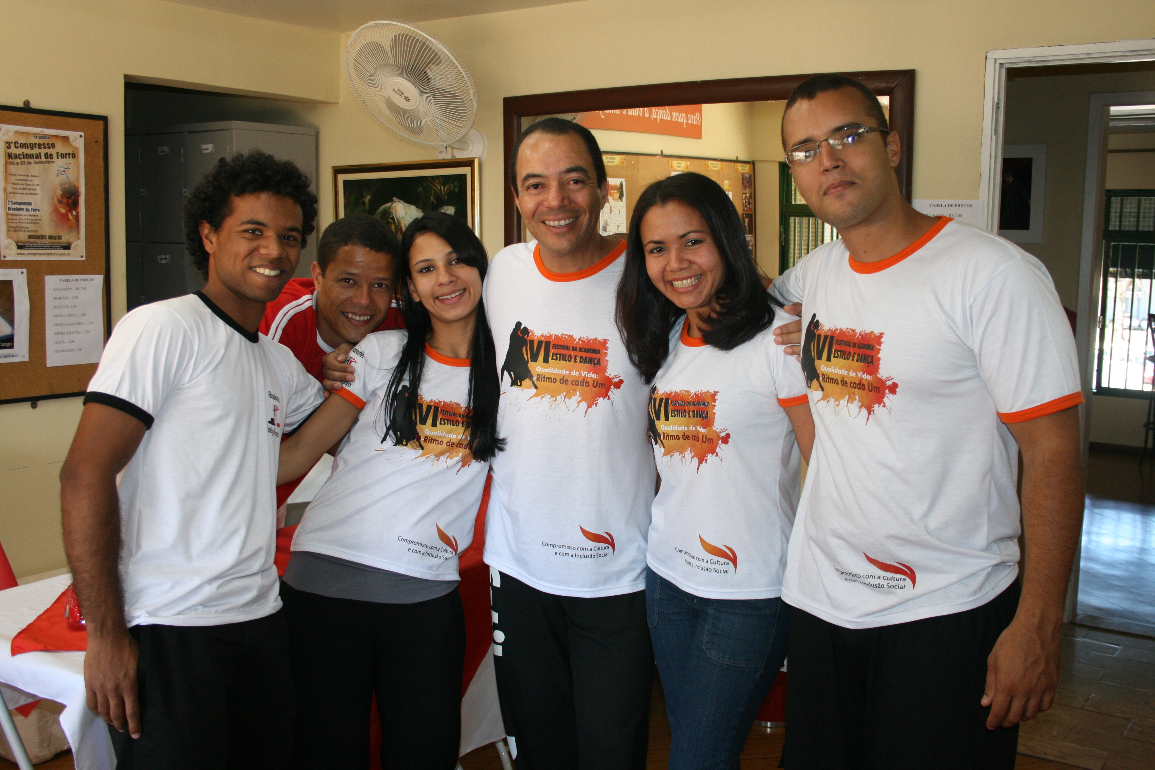 Cinco integrantes com camisetas do evento reunidos em retrato coletivo
