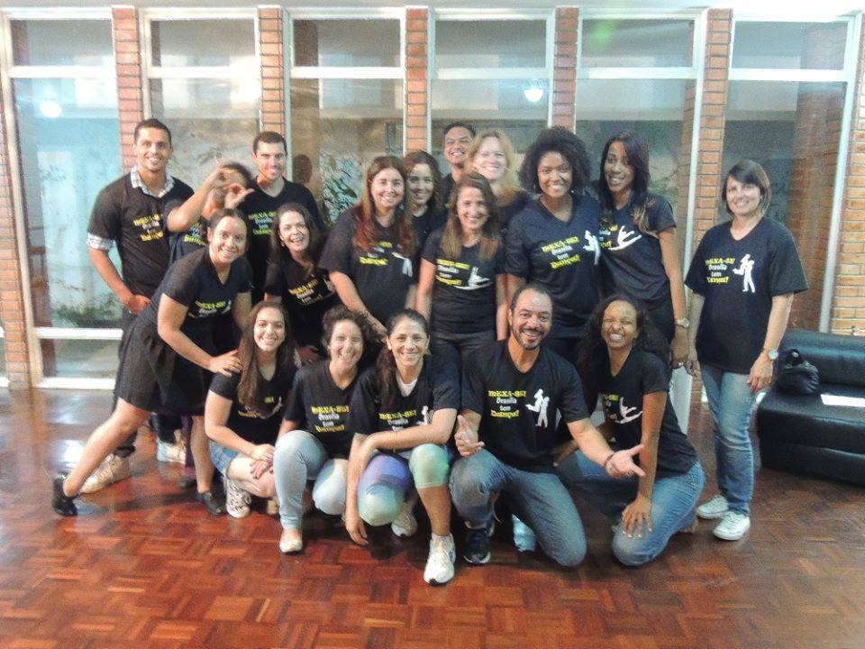 Grupo posa em ambiente interno usando camisetas pretas com a identidade MEXA-SE! Brasília tem Dança.
