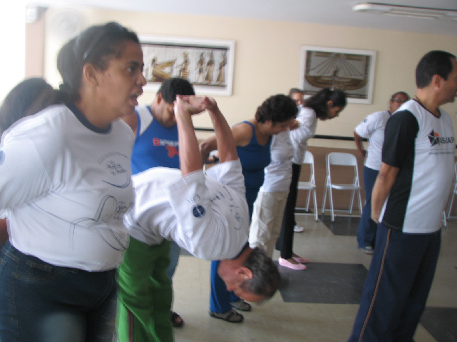 Participantes realizam exercícios corporais em duplas durante a aula
