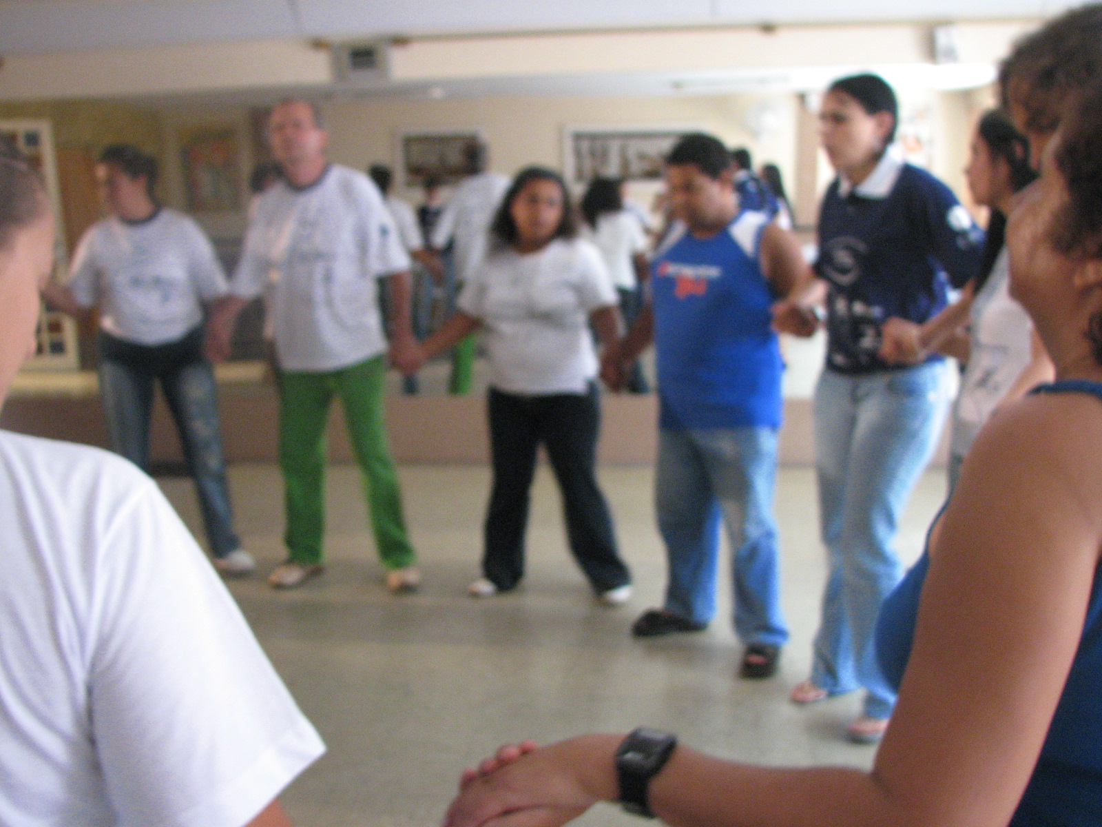 Participantes formam uma roda de mãos dadas durante exercício coletivo