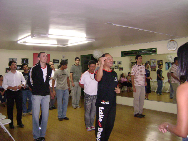 Participantes praticam sequência de movimento durante aula coletiva