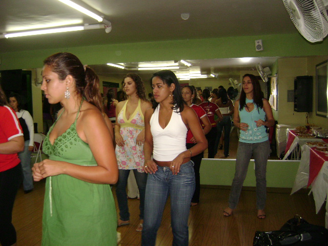 Participantes acompanham exercício coletivo durante aula de dança