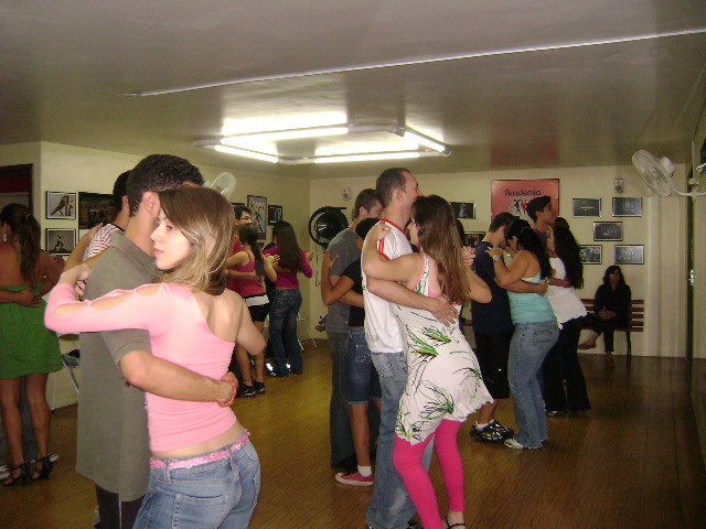 Diferentes duplas praticam dança de salão durante atividade coletiva