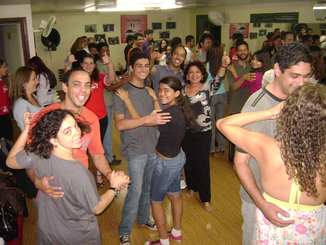Diversas duplas praticam dança de salão em atividade coletiva