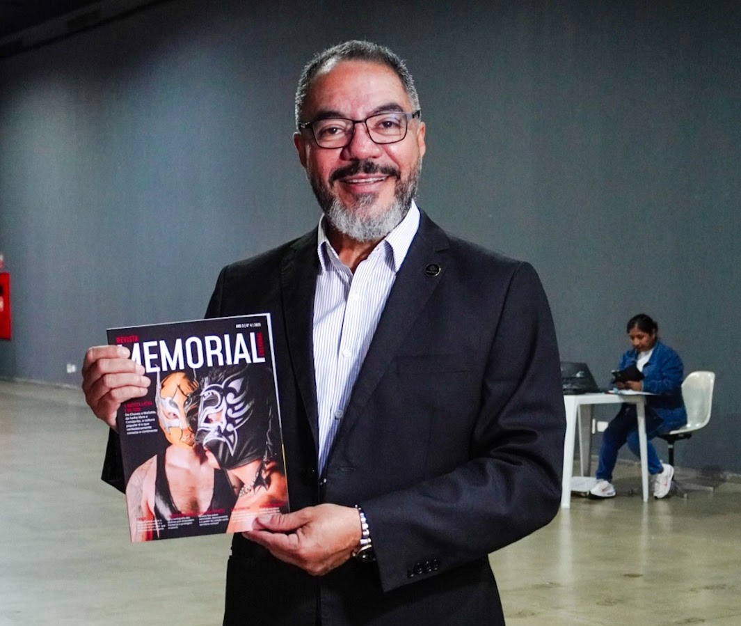 João Carlos Corrêa sosteniendo la Revista Memorial Cultural n.º 4 durante un evento