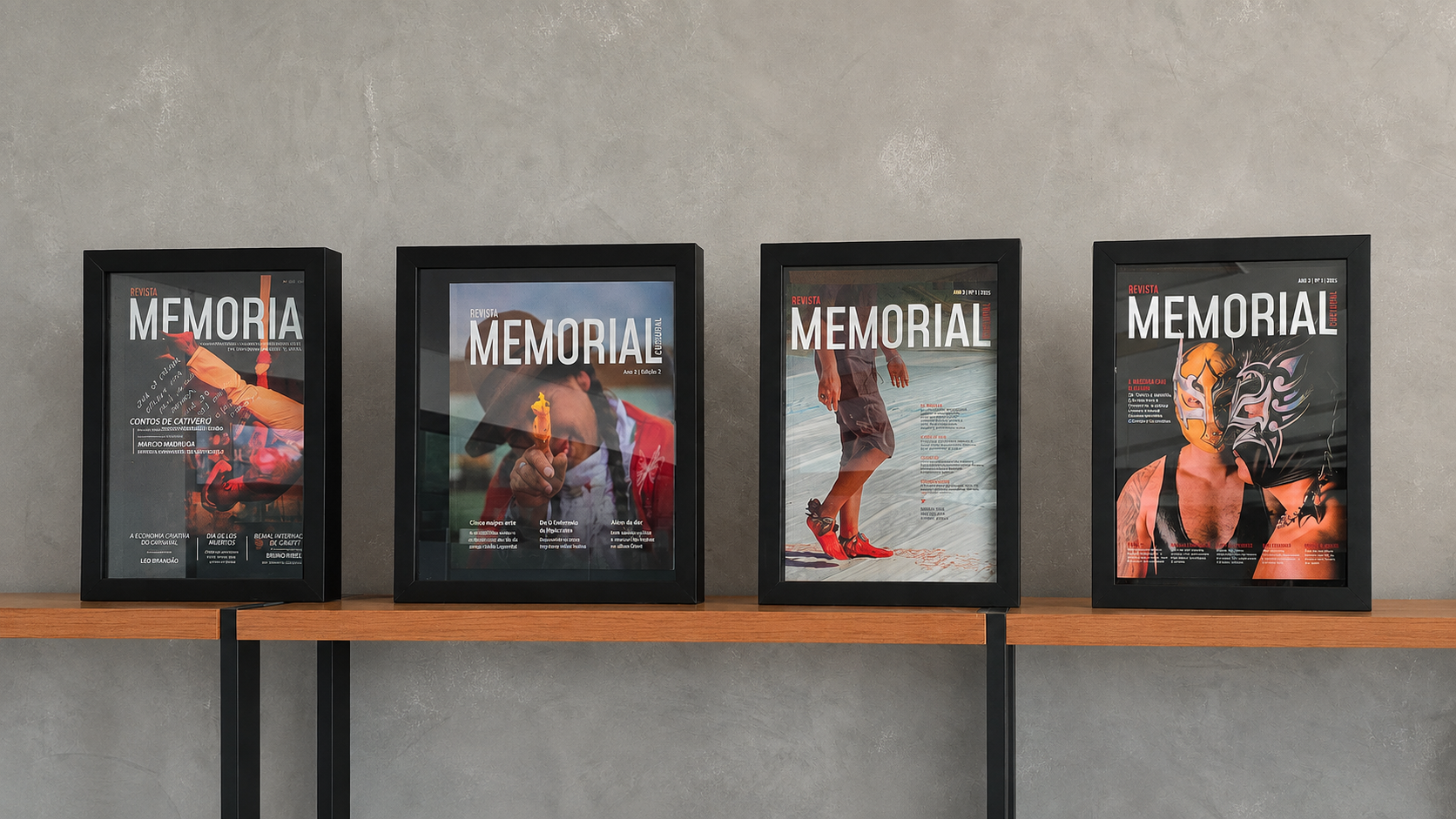 Quatro exemplares emoldurados da Revista Memorial Cultural dispostos sobre uma prateleira de madeira