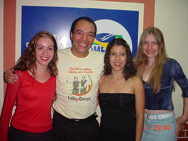 João Carlos Corrêa e três participantes reunidos diante da identidade visual da programação