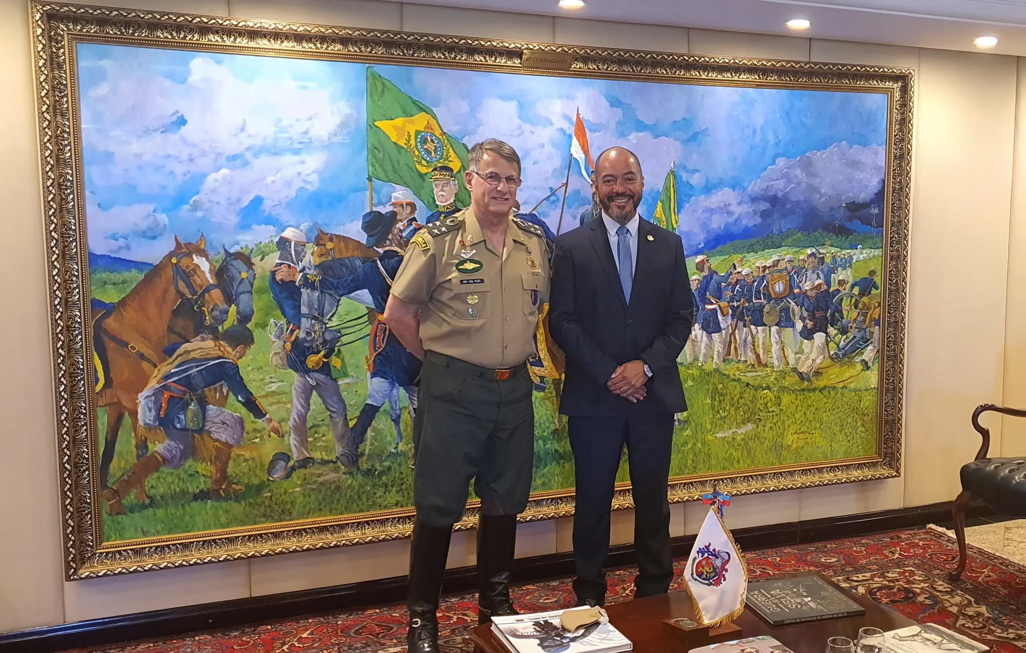 João Carlos Corrêa ao lado do comandante do Exército Brasileiro, general Edson Pujol, diante de pintura histórica militar.