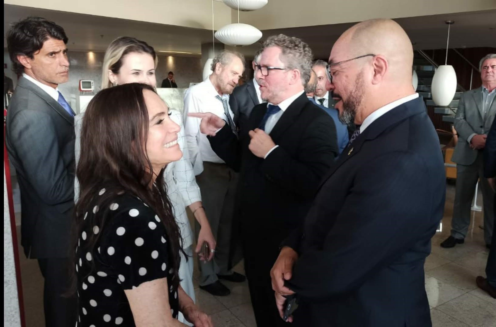 João Carlos Corrêa conversa com a secretária nacional de Cultura, Regina Duarte, durante audiência com outros participantes ao fundo.