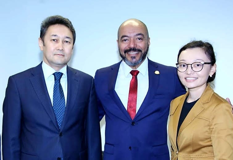 João Carlos Corrêa entre o embaixador Kairat Sarzhanov e outra participante durante recepção institucional.