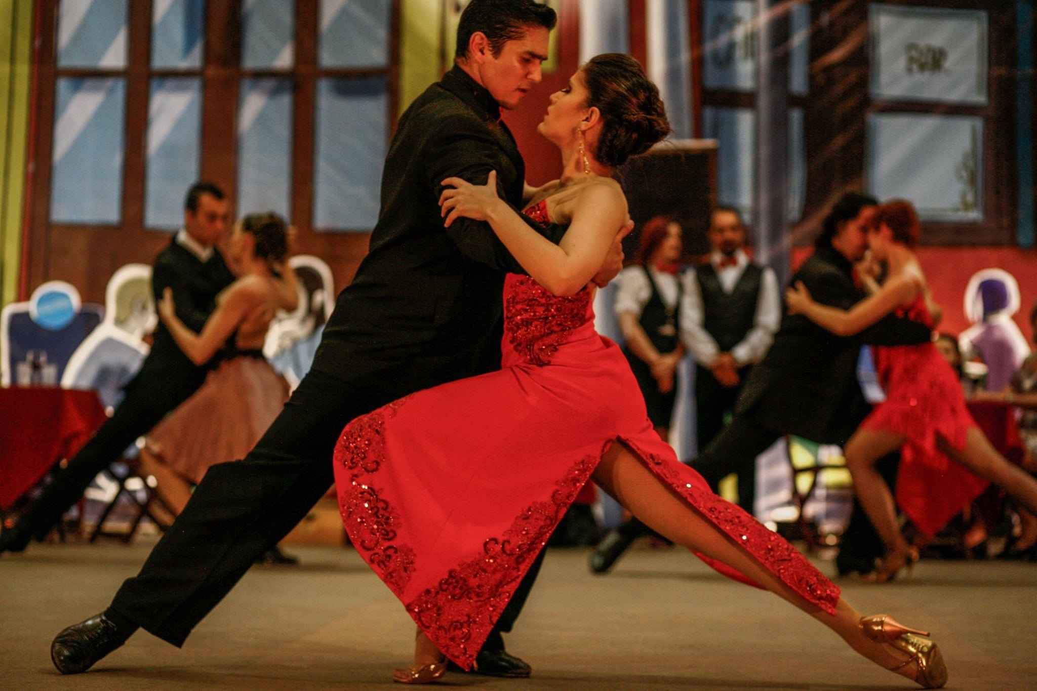 Juliano Andrade y Paula Emerick bailan tango en primer plano mientras otras parejas se presentan al fondo