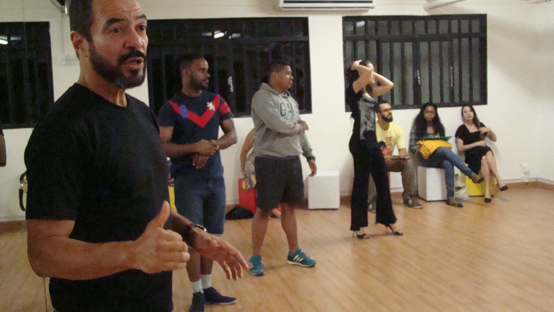 Integrante de la dirección orienta a los participantes durante un ensayo de Tangos e Luares en el estudio