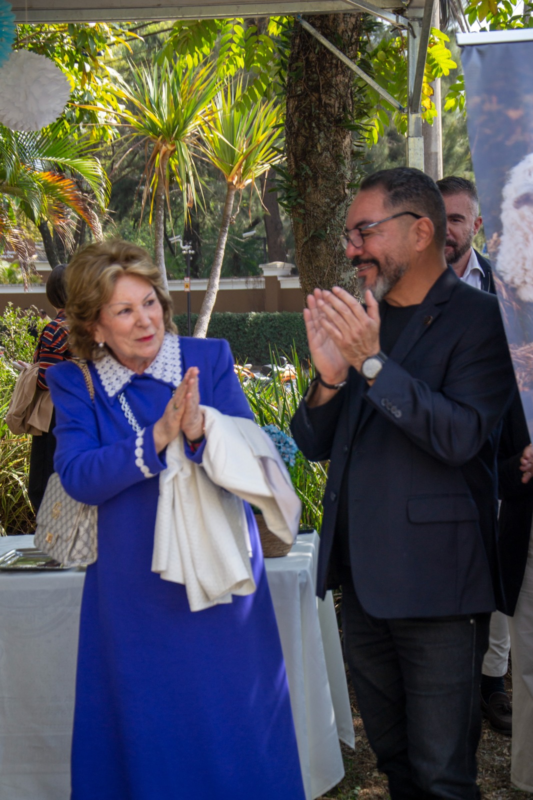 Marta Echarte y João Carlos Corrêa aplauden en una actividad externa realizada en un área ajardinada