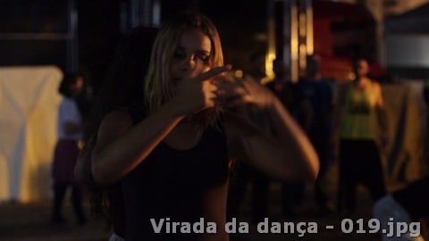 Participante realiza movimentos com as mãos em primeiro plano durante a atividade noturna.